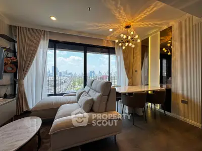 Luxurious living room with stunning city view, elegant chandelier, and modern furniture in high-rise apartment.