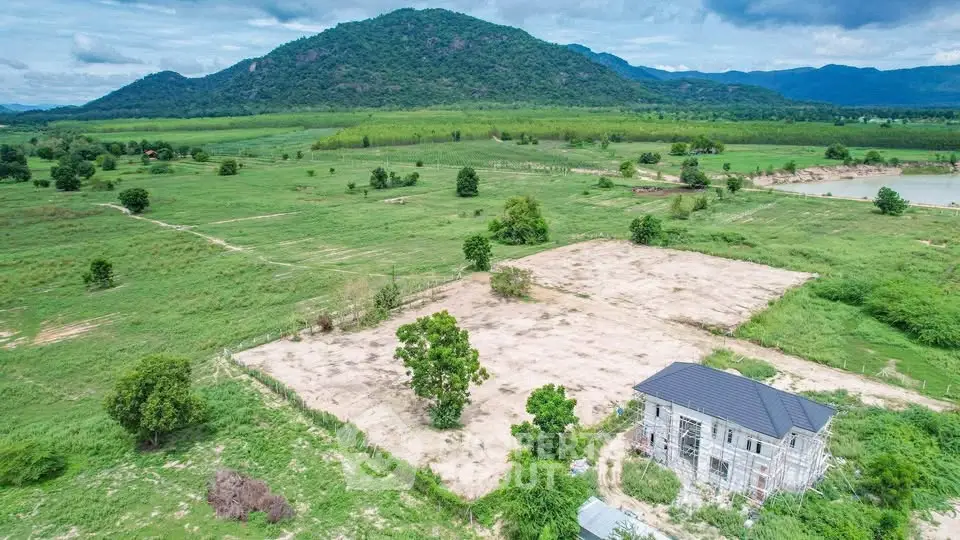 Scenic aerial view of countryside property with lush greenery and mountain backdrop.