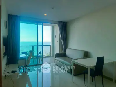 Modern living room with ocean view and balcony access, featuring sleek furniture and natural light.