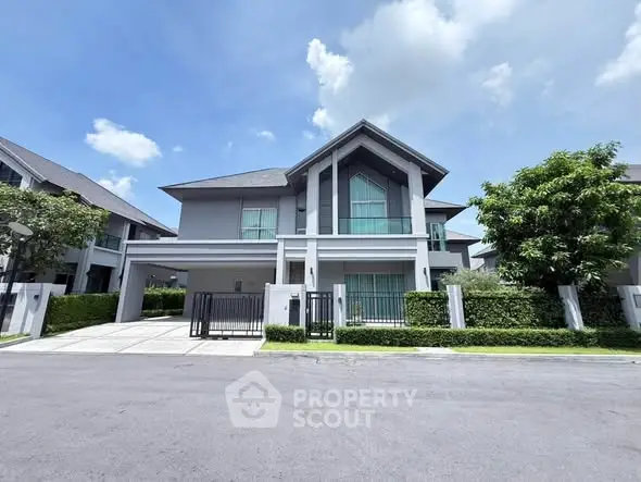 Modern two-story house with sleek design and lush greenery in a serene neighborhood.