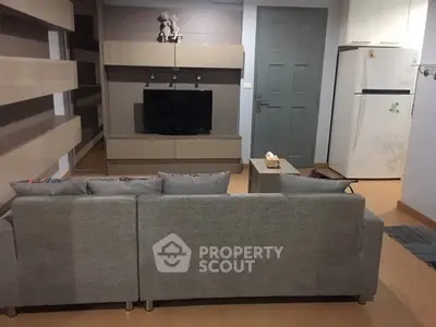 Modern living room with sleek grey sofa and wall-mounted TV unit
