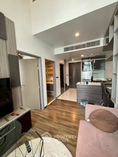 Modern open-plan living room with kitchen, featuring sleek design and cozy ambiance.