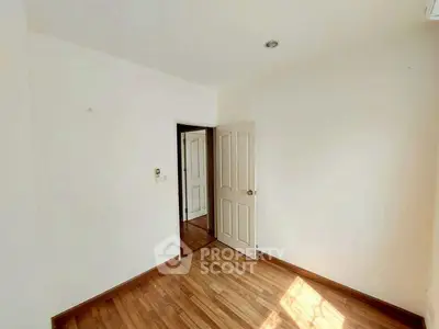 Bright empty room with wooden flooring and white walls, ideal for customization.