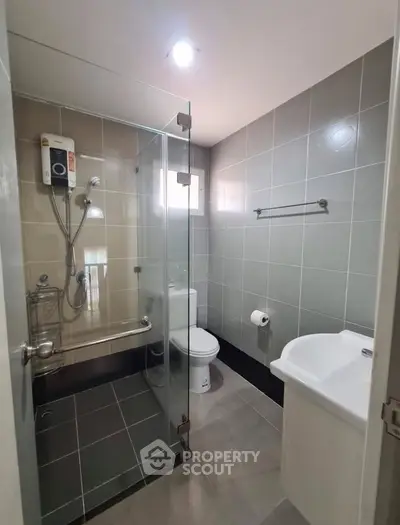 Modern bathroom with glass shower and sleek fixtures in a contemporary home.