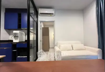 Modern living room with sleek blue kitchen cabinets and cozy white sofa, perfect for urban living.