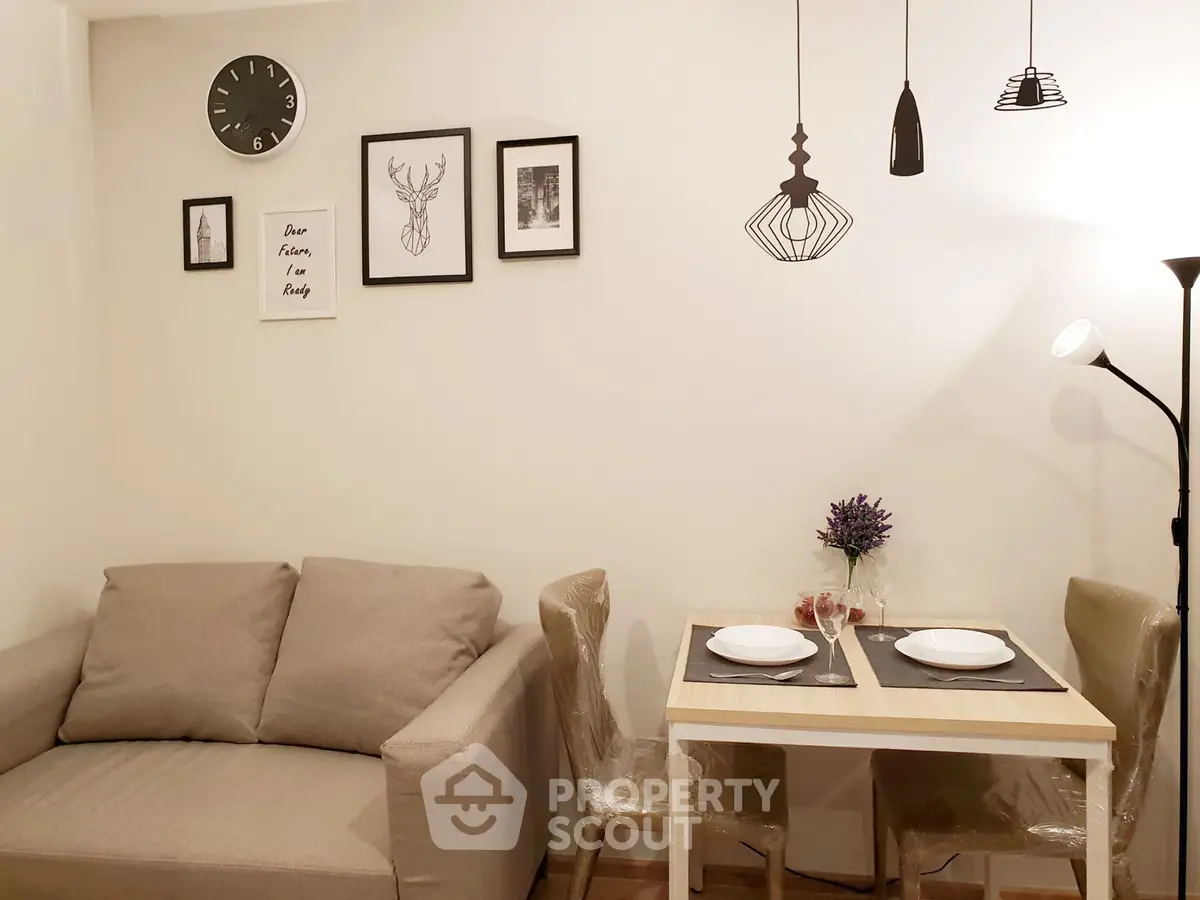 Cozy living room with modern decor and dining area, featuring stylish wall art and elegant lighting.