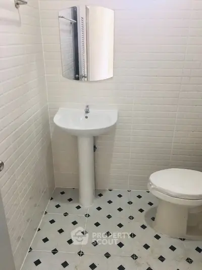 Compact bathroom with modern white tiles and sleek fixtures, ideal for urban living spaces.