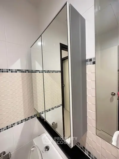 Modern bathroom with sleek mirrored cabinet and stylish tile design