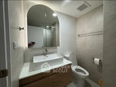 Modern bathroom with sleek fixtures and elegant design, featuring a large mirror and stylish vanity.