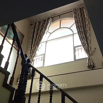Elegant staircase with large window and stylish curtains