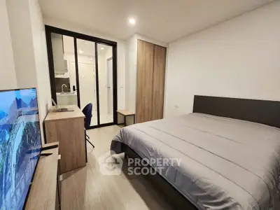Modern bedroom with sleek design and ensuite bathroom in a stylish apartment.