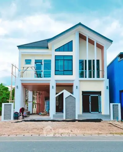 Modern two-story house with large windows and unique architectural design.