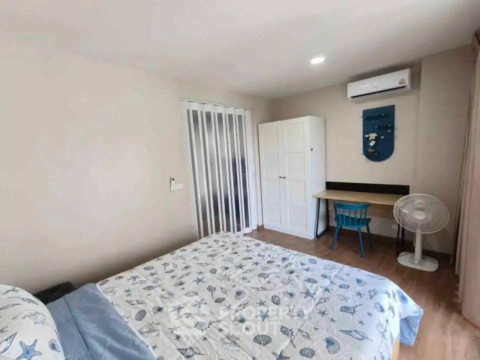 Cozy bedroom with modern decor, featuring a comfortable bed, wardrobe, desk, and air conditioning.