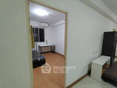 Spacious bedroom with wooden flooring and modern furniture in a cozy apartment.