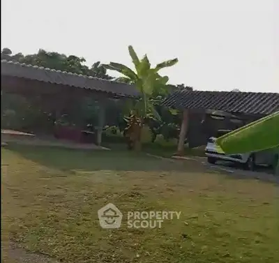 Charming countryside property with lush greenery and spacious outdoor area.