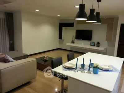 Modern open-layout living room with stylish lighting and cozy seating area.