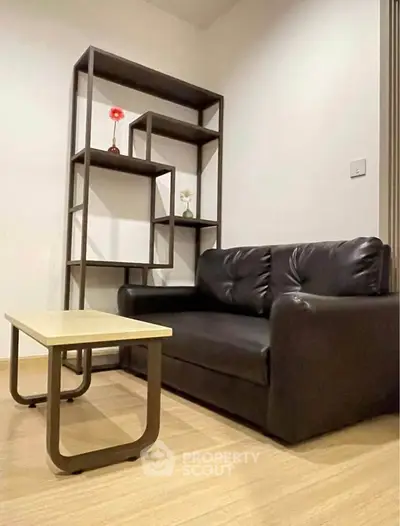 Modern living room with sleek black sofa and stylish shelving unit