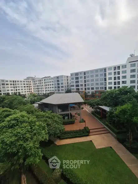 Stunning view of modern apartment complex with lush green gardens and spacious outdoor area.