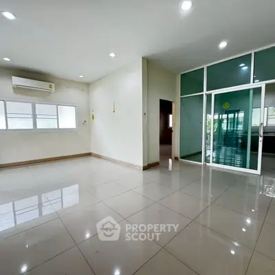 Spacious modern living room with large windows and glass doors