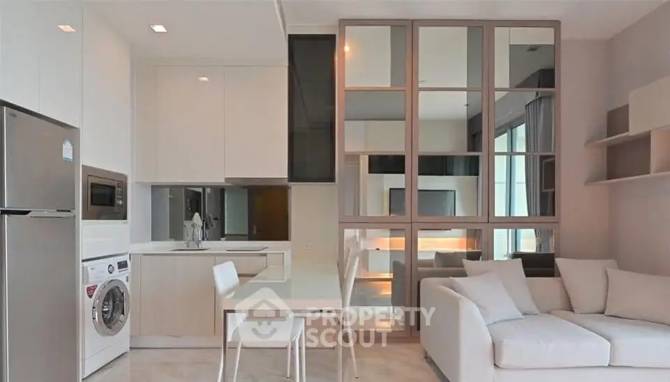 Modern open-layout living room with sleek kitchen and cozy seating area