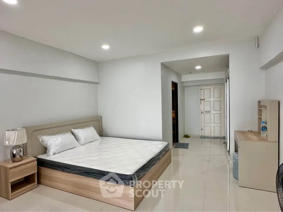 Spacious bedroom with modern furnishings and sleek design in a contemporary apartment.