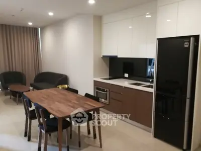 Modern open-layout kitchen and living area with sleek furniture and appliances