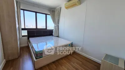 Bright bedroom with city view and wooden flooring