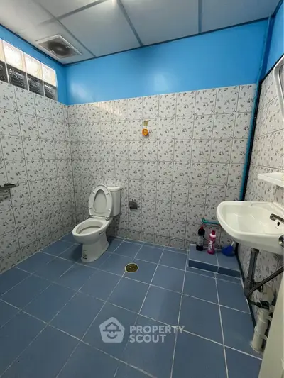 Spacious bathroom with blue tiles and modern fixtures, ideal for comfort and functionality.