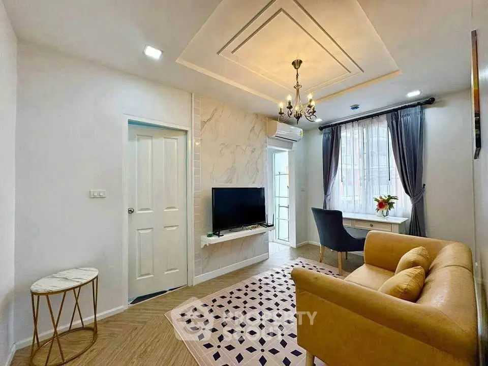 Stylish living room with elegant decor, cozy sofa, and modern TV setup in a bright apartment.