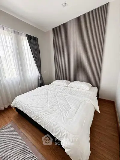 Modern bedroom with stylish accent wall and natural light