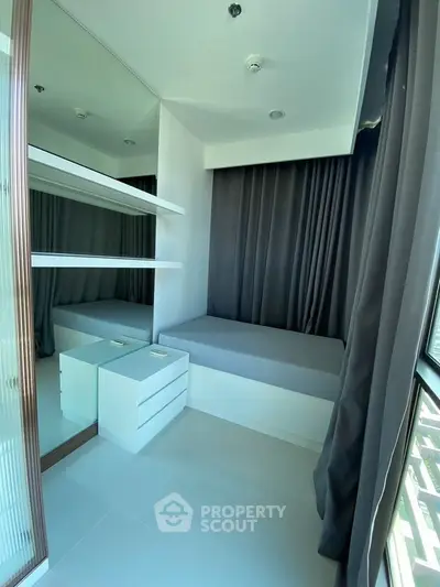 Modern bedroom with sleek design, featuring built-in shelves and large windows for natural light.