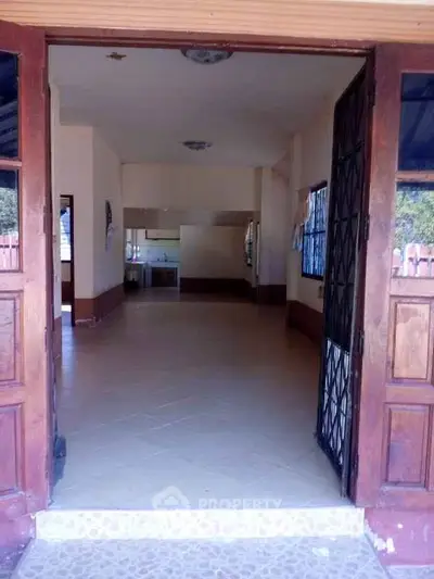 Spacious open-plan living area with tiled flooring and natural light, perfect for modern living.