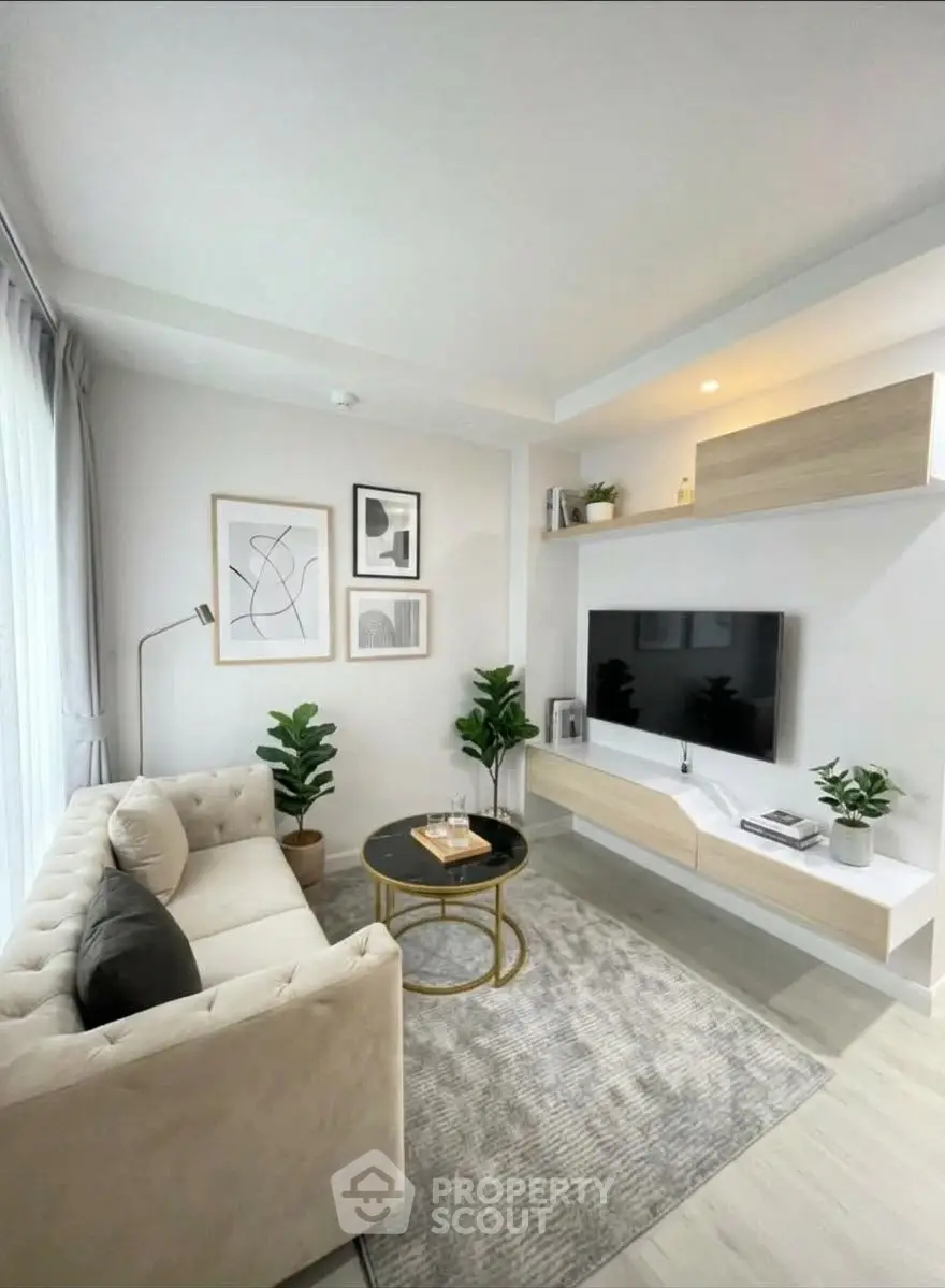 Modern living room with stylish decor, cozy sofa, and wall-mounted TV in a bright, airy space.
