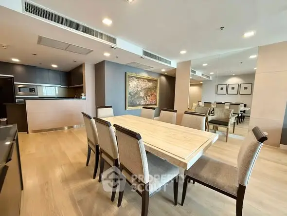 Spacious modern dining area with elegant wooden table and chairs, open kitchen layout, and stylish decor.