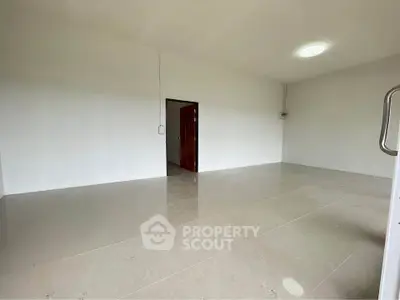 Spacious empty room with glossy tiled flooring and bright lighting, ideal for customization.