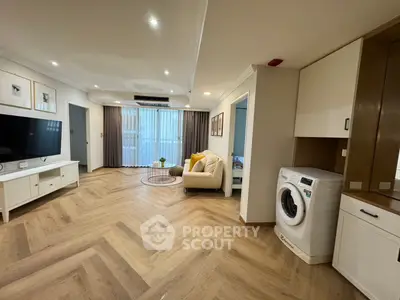 Spacious modern living room with elegant flooring and built-in washing machine