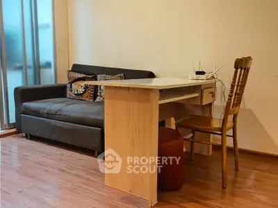 Cozy living room with modern sofa and wooden desk, perfect for work and relaxation.