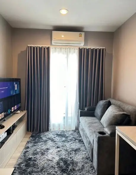 Cozy living room with plush gray sofa and modern entertainment setup.