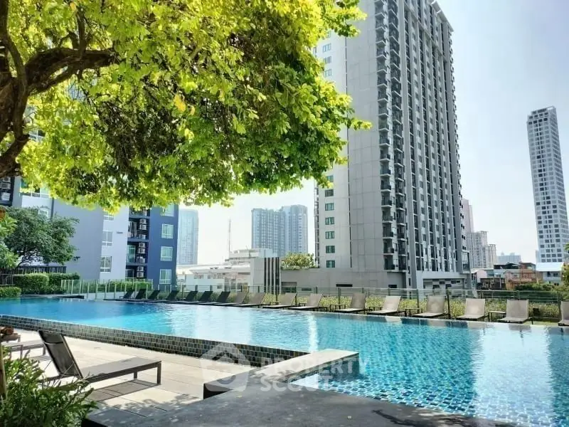 Luxurious apartment complex with stunning pool and city skyline view, perfect for urban living.