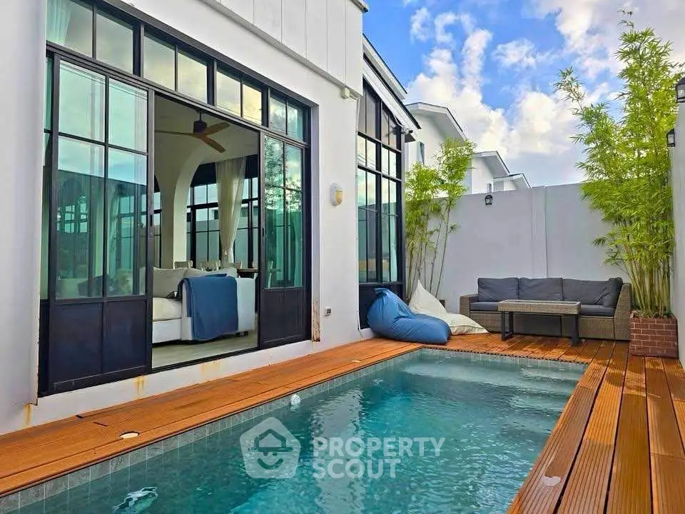 Luxurious modern home with private pool and stylish outdoor seating area, perfect for relaxation.