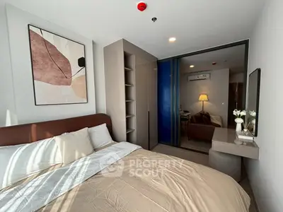 Modern bedroom with stylish decor and natural light, featuring a cozy bed and contemporary artwork.