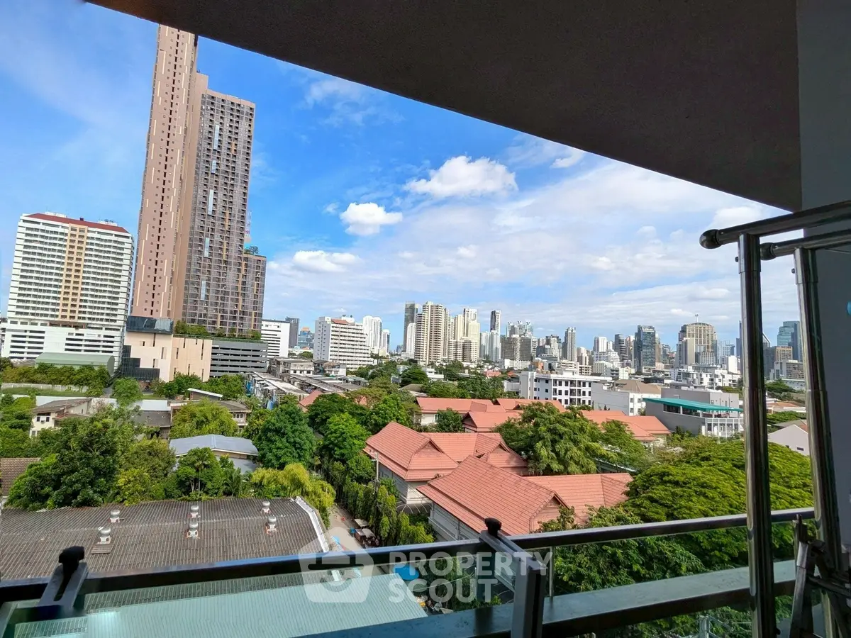 Stunning cityscape view from a high-rise balcony, showcasing urban skyline and lush greenery.
