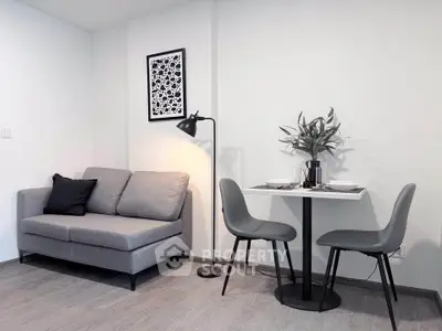 Modern living room with stylish gray sofa and dining area, perfect for cozy urban living.