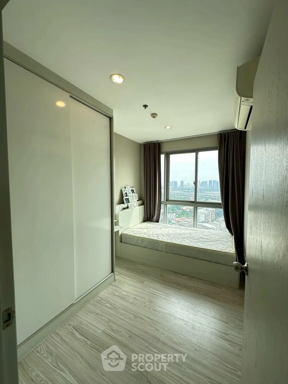 Modern bedroom with city view and sleek design in high-rise apartment