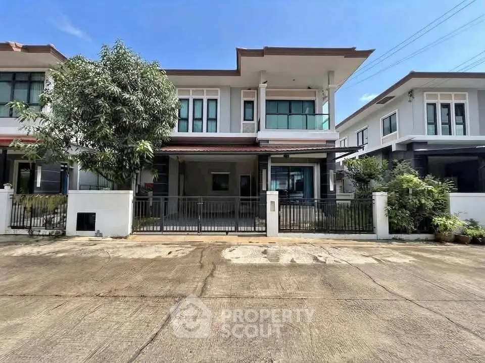 Modern two-story house with spacious driveway and lush greenery in a serene neighborhood.