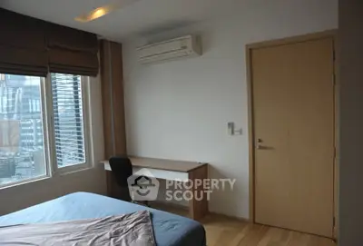 Modern bedroom with large window and study desk, featuring air conditioning and wooden flooring.