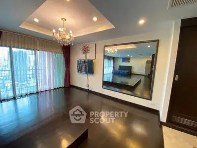 Spacious modern living room with elegant chandelier and large mirror