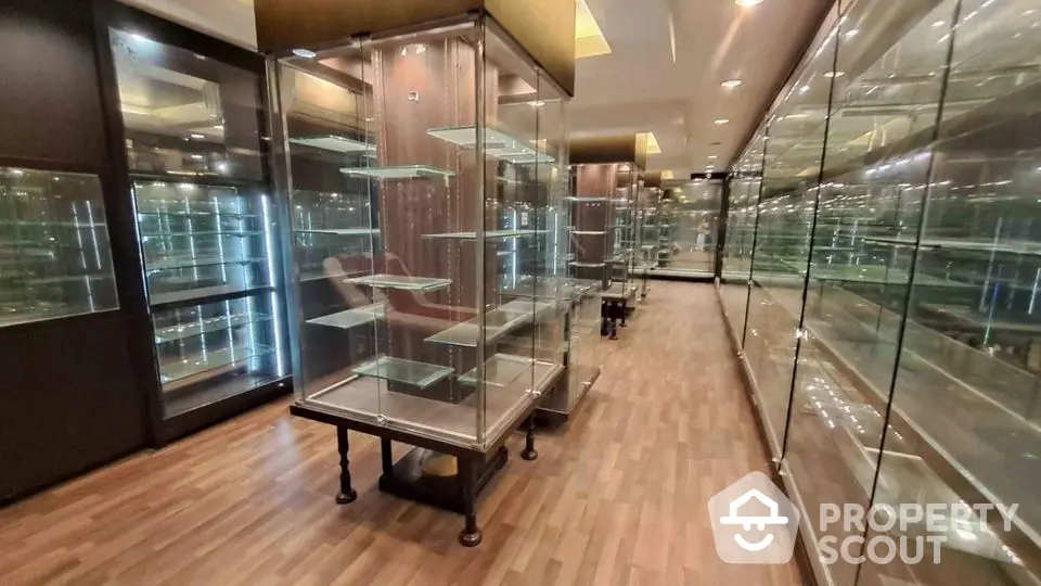 Spacious interior with glass display cabinets and wooden flooring, ideal for showcasing collections.