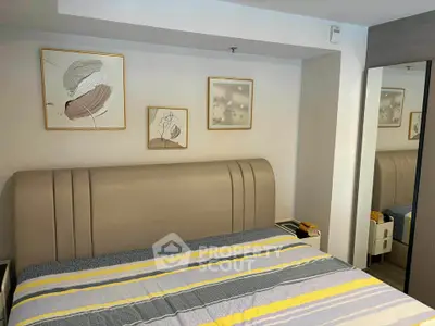 Modern bedroom with stylish decor and cozy ambiance, featuring a comfortable bed and elegant artwork.
