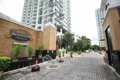 Luxurious condominium entrance with palm trees and modern architecture